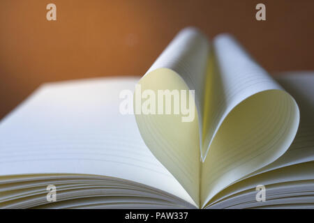 Close up forma di cuore dal libro di carta con spazio copia di sfondo per il testo. Foto Stock