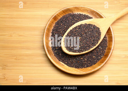1 cucchiaio di semi di senape Nigra su legno Foto Stock