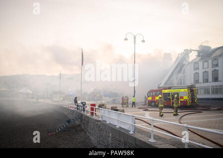 Aberystwyth Wales UK, mercoledì 25 luglio 2018 un grande incendio ha gravemente danneggiato due alberghi contigui su Aberystwyth lungomare. Il Belle Vue Hotel e il Belgrave House Hotel ha preso fuoco intorno a 2am questa mattina, motori Fire da tutta la metà e il Galles occidentale sono stati presenti per tutta la notte. Non ci sono notizie di vittime e tutti gli ospiti sono stati trasferiti in altri alloggi . Gran parte del centro della città è stato isolato per motivi di sicurezza Credito Foto : keith morris/Alamy Live News Foto Stock