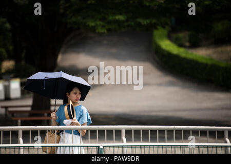 Nagoya, Giappone. Luglio 25, 2018 - una donna usa un ombrellone per evitare il sole a Higashiyama Zoo e Giardino Botanico in Nagoya, Giappone. Alte temperature è proseguito per tutto il paese su mercoledì. La Japan Meteorological Agency ha dichiarato la costante ondata di calore di un disastro naturale, con 65 decessi segnalati nel corso della settimana passata. L'agenzia ha previsto ha continuato a temperature elevate nelle prossime settimane. Credito: Ben Weller/AFLO/Alamy Live News Foto Stock