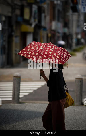 Nagoya, Giappone. Luglio 25, 2018 - una donna usa un ombrellone per evitare il sole in Nagoya, Giappone. Alte temperature è proseguito per tutto il paese su mercoledì. La Japan Meteorological Agency ha dichiarato la costante ondata di calore di un disastro naturale, con 65 decessi segnalati nel corso della settimana passata. L'agenzia ha previsto ha continuato a temperature elevate nelle prossime settimane. Credito: Ben Weller/AFLO/Alamy Live News Foto Stock