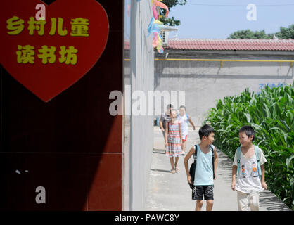 Xingtai cinese nella provincia di Hebei. Xxv Luglio, 2018. Gli studenti a piedi verso una sala lettura a Dongma villaggio nel distretto di Qiaoxi di Xingtai, città del nord della Cina nella provincia di Hebei, 25 luglio 2018. Dongma la scuola primaria ha impostato gli scaffali e distribuito un totale di più di mille libri in 13 abitanti di un villaggio case per gli studenti a leggere. Credito: Tian Xiaoli/Xinhua/Alamy Live News Foto Stock