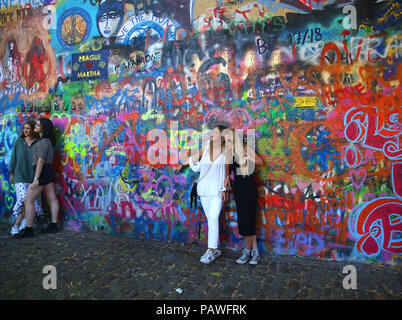 Praga, Repubblica Ceca. 14 Luglio, 2018. I turisti pongono di fronte alla parete di Lennon o John Lennon parete è una parete a Praga, Repubblica Ceca. Una volta che una normale parete, sin dagli anni ottanta è stato riempito con John Lennon-ispirato graffiti e pezzi di testi dal Beatles" canzoni. Credito: Leigh Taylor/ZUMA filo/Alamy Live News Foto Stock