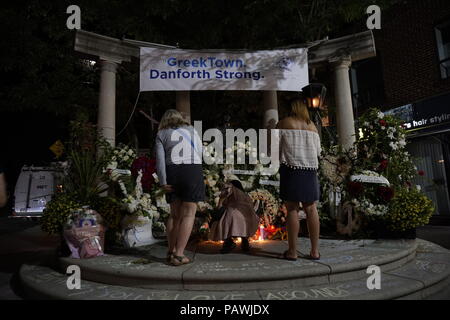 Toronto, Canada. Il 25 luglio 2018. Le persone che frequentano la luce di una candela veglia in città greca sul Danforth Avenue dove le vittime sono state scattate da bandito il 22 luglio 2018. Fiori, candele e i messaggi sono ovunque Credito: CharlineXia/Alamy Live News Foto Stock