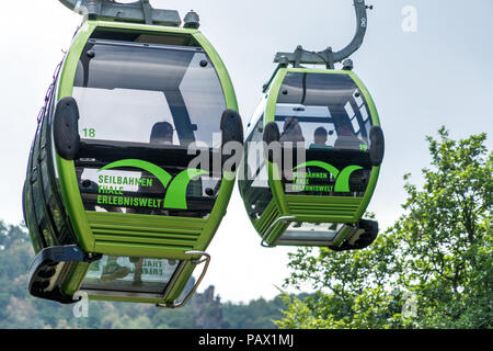 Thale, Sassonia-Anhalt, Germania, 23 luglio. 2018: due cabine verde del cavo auto da Thale nella catena montuosa di Harz oltre l'estate verde alberi contro t Foto Stock