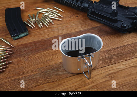 Fucile e tazza di caffè sul tavolo in legno sfondo Foto Stock