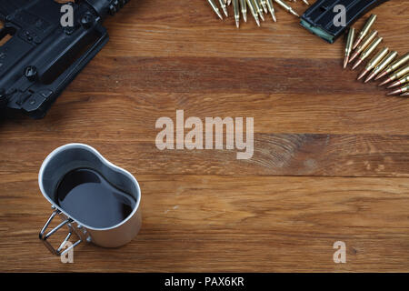 Fucile e tazza di caffè sul tavolo in legno sfondo Foto Stock