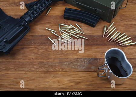 Fucile e tazza di caffè sul tavolo in legno sfondo Foto Stock