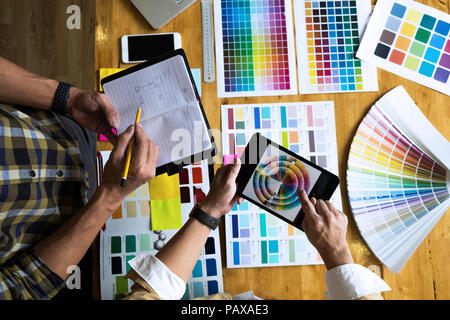 Graphic Designer utilizzano la tavoletta per scegliere i colori dal bar esempio per le idee di design, design creativo del designer di grafica concetto. Foto Stock