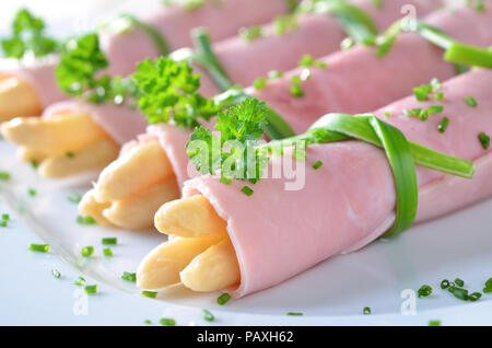 Laminati prosciutto bollito farcito con asparagi Foto Stock