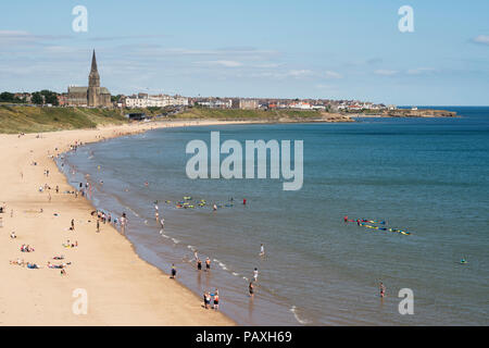 Per coloro che godono di un sole estivo sul Longsands Tynemouth beach, Cullercoats in background, North East England, Regno Unito Foto Stock