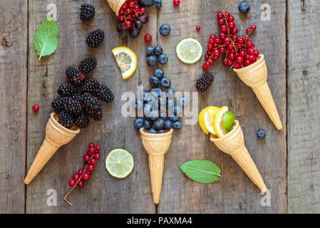 Bacche di coni gelato (mirtillo, ribes, limone, blackberry, uva). Estate sano concetto di cibo. Foto Stock