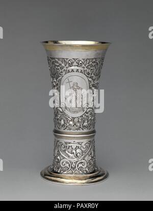 Footed becher. Cultura: Ungherese, Brassó. Dimensioni: complessivo: 8 1/2 x 5 1/8 in. (21,6 x 13 cm). Autore: Jeremias Jekel (master 1618, morto 1667). Data: ca. 1600. Questo bicchiere documenti l'adattamento di stili e di motivi creati migliaia di chilometri di distanza. La nave è coperto in un sofisticato sistema ornamentali di fitte scrollwork con frutti abbondanti i cluster e sospesi baldachins--il simbolo per eccellenza della royal o il potere ecclesiastico-sormontano le tre riserve ovale. Le tre figure intagliate nel separare ovali rappresentano le virtù teologali - fede, speranza e carità. Esse derivano da p Foto Stock