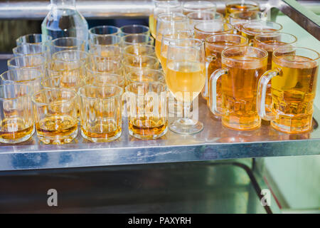 La fabbrica di birra, le bevande e il concetto di alcool ,i diversi tipi di bevande/bevande in bicchieri sul carrello pronto a servire in parte. Foto Stock