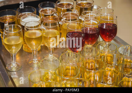 La fabbrica di birra, le bevande e il concetto di alcool ,i diversi tipi di bevande/bevande in bicchieri sul carrello pronto a servire in parte. Foto Stock