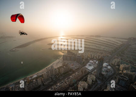 DUBAI, Emirati Arabi Uniti - 16 Febbraio 2018: SkyHub Paramotor volo in tandem da Dubai Marina al di sopra di Palm Jumeirah a Dubai, UAE al crepuscolo Foto Stock