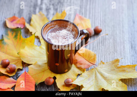Autunno tazza di caffè, noci, cioccolato e foglie di autunno. Autunno sfondo. Scena d'autunno. Caffè e foglie di autunno. Foto Stock