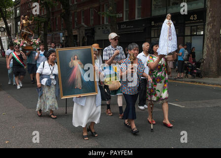 Filippino italiano multietnico londinese Regno Unito. I cattolici romani a Londra partecipano alla processione annuale, una festa religiosa della Chiesa italiana di San Pietro a Clerkenwell. Si trattano intorno all'area trasportando ikon religiosi, quadri e statue. L'evento annuale si svolge a luglio nel centro di Londra nel Regno Unito negli anni '2018 2010 di HOMER SYKES Foto Stock