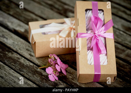 Confezioni regalo di marshmallows dal pasticcere, un complimento.su uno sfondo di legno. Romanticismo Foto Stock