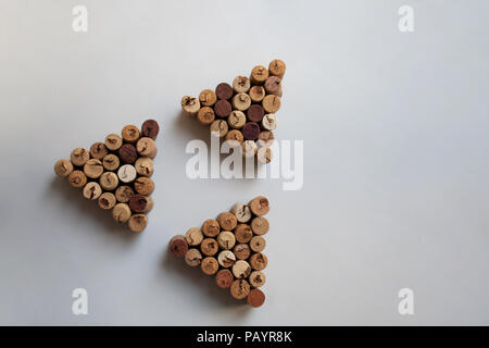 Tre tappi vino triangoli disposti in forma triangolare su sfondo bianco con spazio di copia Foto Stock