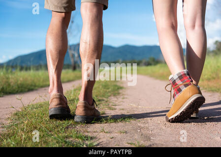 Chiudere fino alla parte inferiore delle gambe di due viaggiatori camminando lungo il sentiero in natura. Escursionismo e campeggio concetto. Backpacker un concetto turistico. Attività all'aperto e Foto Stock