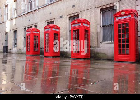 London, Regno Unito - cabine telefoniche rosse bagnato in condizioni di tempo piovoso. Vista ampia corte, Covent Garden. Foto Stock