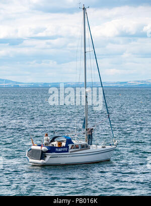 Giovane su yacht chiamati Pompero vela al di fuori della baia nel Firth of Forth, North Berwick, East Lothian, Scozia, Regno Unito Foto Stock