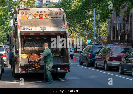 New York Dipartimento di Igiene dei lavoratori compost vuota cassonetti per i rifiuti organici programma di raccolta al di fuori di un edificio residenziale nel quartiere di Chelsea di New York Sabato, 14 luglio 2018 . (Â© Richard B. Levine) Foto Stock