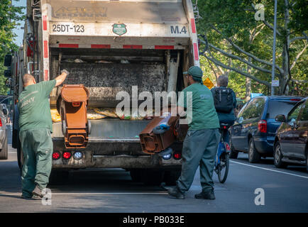 New York Dipartimento di Igiene dei lavoratori compost vuota cassonetti per i rifiuti organici programma di raccolta al di fuori di un edificio residenziale nel quartiere di Chelsea di New York Sabato, 14 luglio 2018 . (Â© Richard B. Levine) Foto Stock