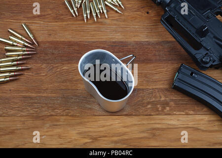 Fucile e tazza di caffè sul tavolo in legno sfondo Foto Stock