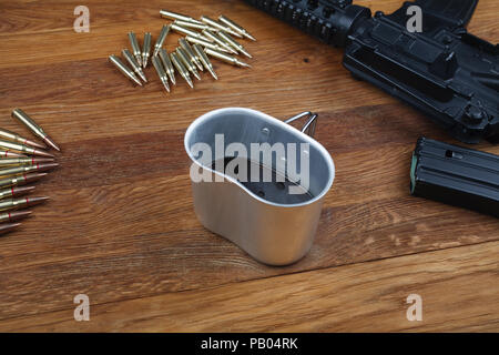 Fucile e tazza di caffè sul tavolo in legno sfondo Foto Stock