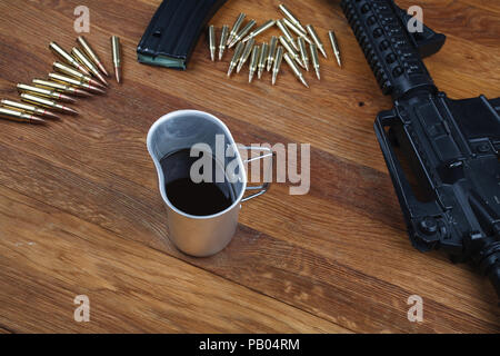 Fucile e tazza di caffè sul tavolo in legno sfondo Foto Stock