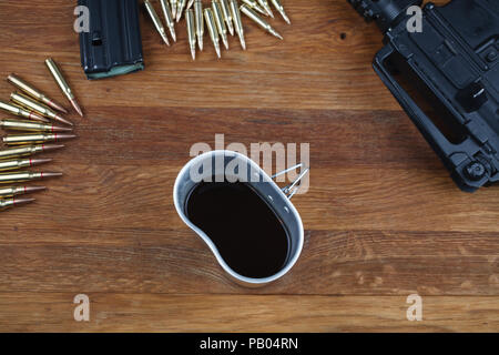 Fucile e tazza di caffè sul tavolo in legno sfondo Foto Stock