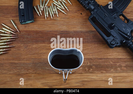 Fucile e tazza di caffè sul tavolo in legno sfondo Foto Stock