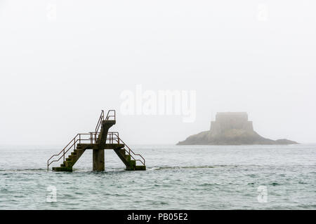 La piattaforma di immersione delle maree piscina di Bon Secours beach, a Saint-malo, Francia, da un nebbioso giorno con il Petit essere isola in background. Foto Stock