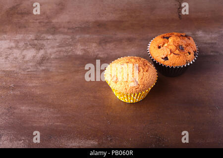 Gustosi tortini di cioccolato, muffin su una bianca tavolo in legno. Foto Stock