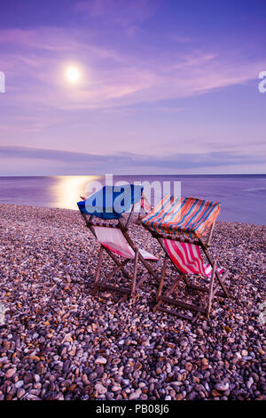 Sedie a sdraio sulla spiaggia al chiaro di luna. Foto Stock