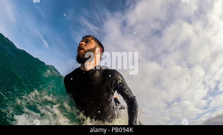Surfer la cattura di un'onda, Camps Bay, Western Cape, Sud Africa Foto Stock