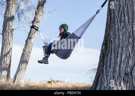 Donna seduta in amaca di bere caffè, Wyoming America, STATI UNITI D'AMERICA Foto Stock