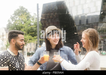 Tre amici sorridente facendo un brindisi celebrativo Foto Stock