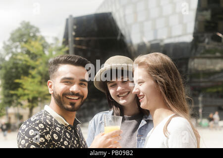 Tre amici sorridente facendo un brindisi celebrativo Foto Stock