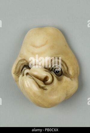 Netsuke di maschera con uomo faccia discriminanti. Cultura: il Giappone. Dimensioni: H. 2. (5,1 cm); W. 1 5/8 in. (4.1 cm); D. 1 1/8 in. (2.9 cm). Data: del XIX secolo. Museo: Metropolitan Museum of Art di New York, Stati Uniti d'America. Foto Stock