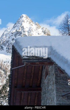 Il tetto della casa sotto uno spesso strato di neve Foto Stock