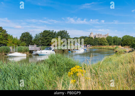 Barche ormeggiate sul fiume Arun in estate in alta marea, con il Castello di Arundel e cielo blu in background in Arundel, West Sussex, in Inghilterra, Regno Unito. Foto Stock