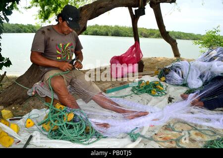 Pescatore che fissa le reti da pesca - Porto di Puerto Pizarro. Dipartimento di Tumbes .Perù la riparazione Foto Stock