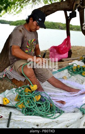 Pescatore che fissa le reti da pesca - Porto di Puerto Pizarro. Dipartimento di Tumbes .Perù la riparazione Foto Stock