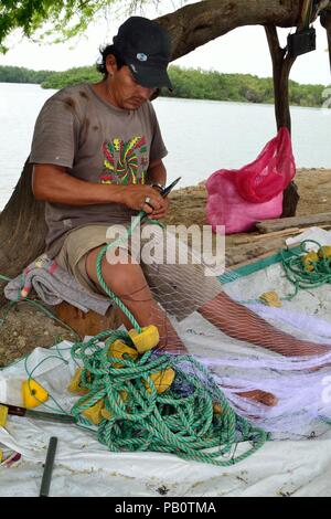 Pescatore che fissa le reti da pesca - Porto di Puerto Pizarro. Dipartimento di Tumbes .Perù la riparazione Foto Stock