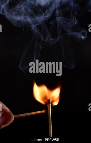 In prossimità di una partita su uno sfondo nero. Ho acceso un matchstick su uno sfondo scuro per vedere tutti i dettagli della sequenza di accensione. Foto Stock