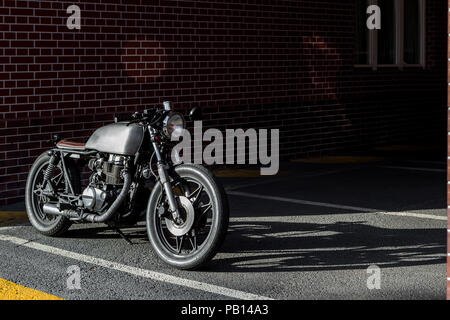 Custom Moto parcheggio nei pressi di un muro di mattoni di edificio delle finanze. Tutto è pronto per divertirsi dopo la dura giornata in ufficio. Imprenditore tanga città ho Foto Stock