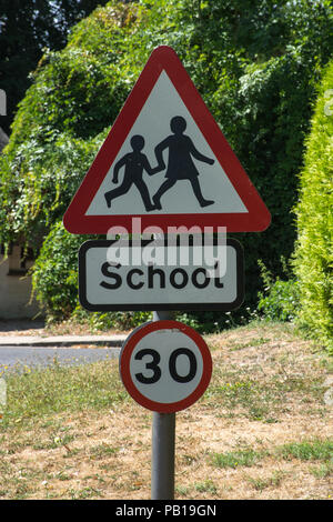 Cartello stradale di avvertimento di una scuola, segno triangolare con bambini, 30 km/h il limite di velocità Foto Stock